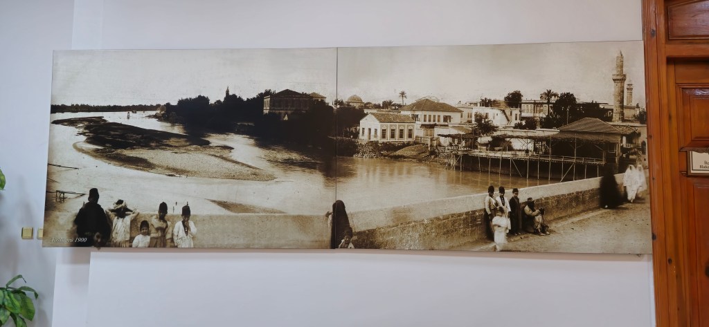 Bir nehir ve çevresinde tarihi binaların görüntüsü, 1900 yılına ait eski bir fotoğraf.